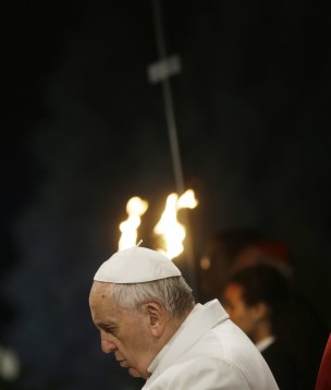 Pope Francis prays in front of the Colosseum during the Via Crucis (Way of the Cross) torchlight procession on Good Friday in Rome, Friday, April 3, 2015. (AP Photo/Gregorio Borgia)